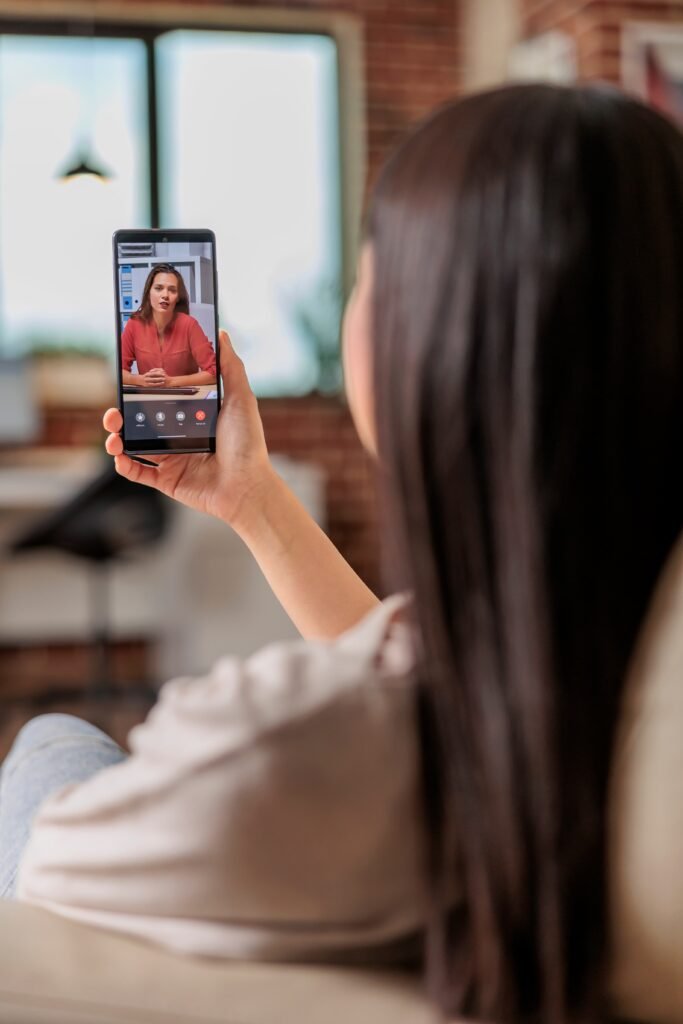Woman using a smartphone for a video call from her home